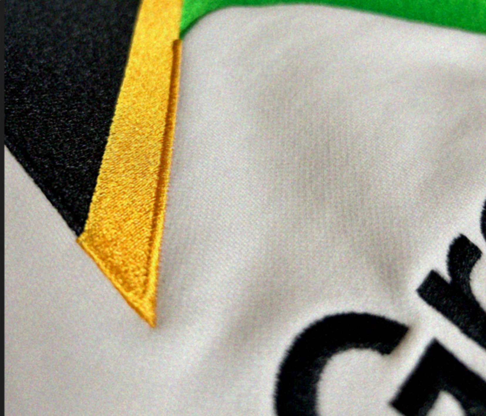 Close up of the corner of the Jamaican flag embroidered onto luxury off-white hoodie